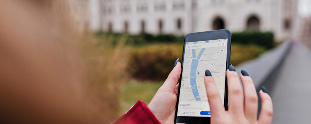 Woman with trendy manicure using gps for search right way. Photo of female hands with smartphone.